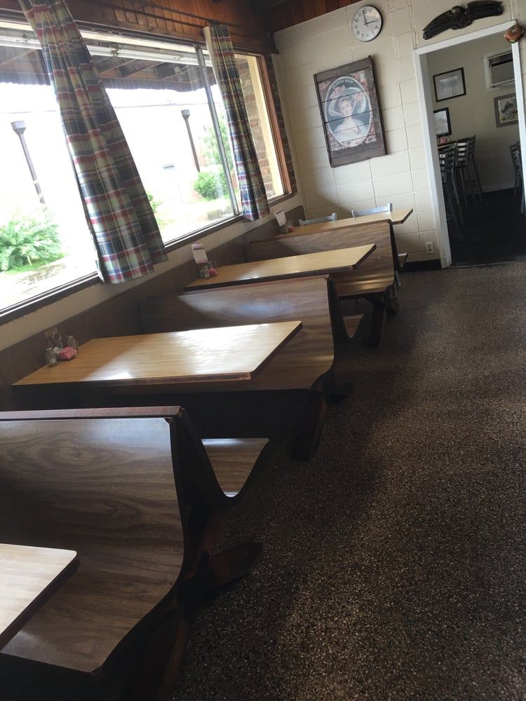 Wooden booths under plaid-curtained windows in the dining room