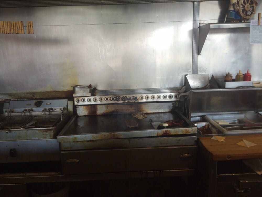 The well-seasoned flat-top grill and fryers behind the counter