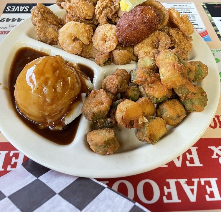 Fried seafood platter with shrimp, a hushpuppy, fried okra and mashed potatoes with gravy